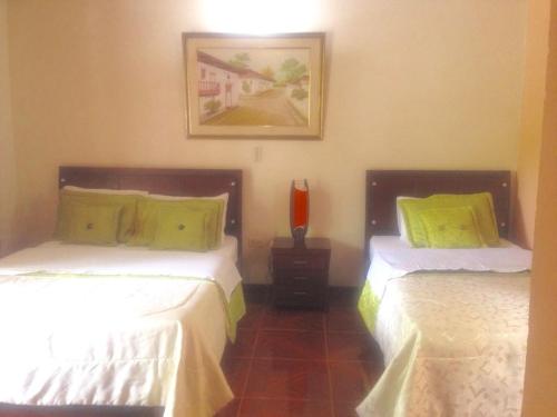 two beds sitting next to each other in a room at Hosteria Campestre San Fermin in Ráquira