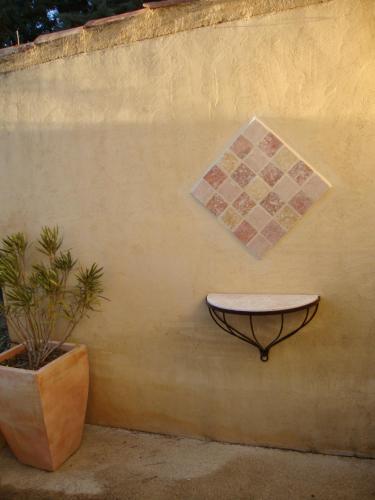 a sink on the side of a wall next to a plant at La Guéritaulde in La Tour-dʼAigues