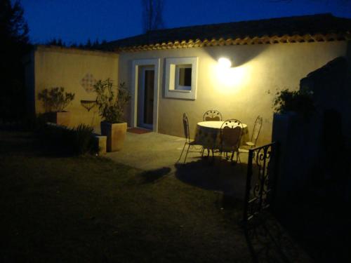 a table and chairs in front of a house at night at La Guéritaulde in La Tour-dʼAigues