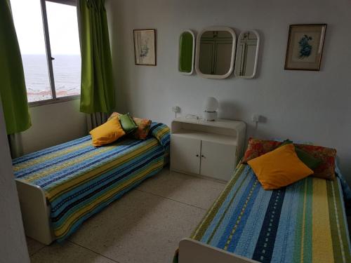 1 dormitorio con 2 camas, lavabo y espejo en Torre Gorlero, en Punta del Este