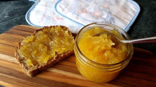 a piece of bread and a jar of jam and a spoon at Tam Coc Boutique Garden in Ninh Binh