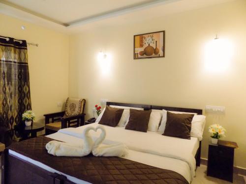 a bedroom with a bed with a swan on it at Mistywindvalley in Kudayattūr