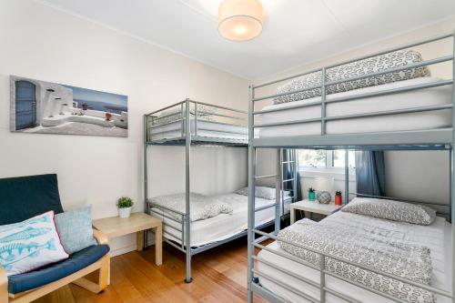 a bedroom with two bunk beds and a couch at Bay Cottage in Sorrento