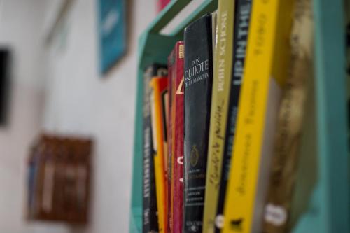 a row of books on a book shelf at Hostel Áabilo'ob in Progreso