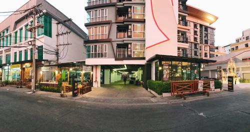 a building with a red arrow on it next to a street at Central Mansion in Bangkok