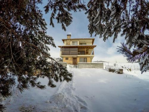 a house in the snow with a pile of snow at Divna Guest House in Dospat