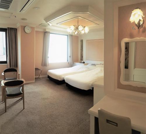 a hotel room with two beds and a chair at Royal Hotel Shinokubo in Tokyo