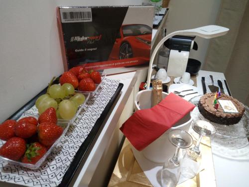 a kitchen counter with strawberries and a cake on it at H5-5H Luxury Room in Maranello