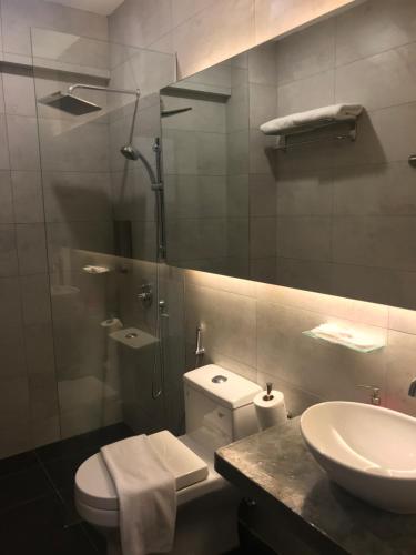 a bathroom with a shower and a toilet and a sink at The Corner House in Pontian Kecil