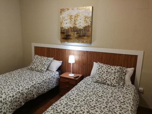 een slaapkamer met 2 bedden en een schilderij aan de muur bij Apartamento en Fuengirola in Fuengirola