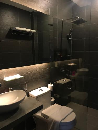 a bathroom with a toilet and a sink at The Corner House in Pontian Kecil