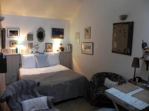a bedroom with a bed and a chair at Les chambres du Chat Perché in Le Havre