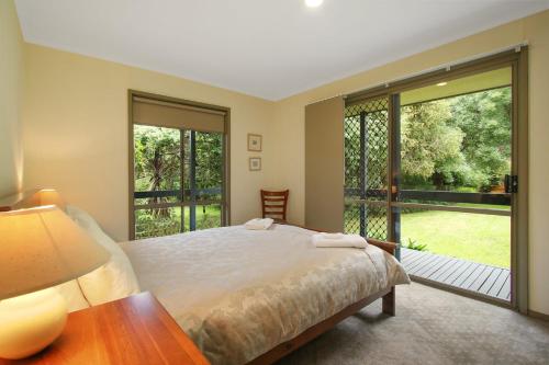 a bedroom with a bed and a large window at Rail Trail Cottage - BRIGHT in Bright