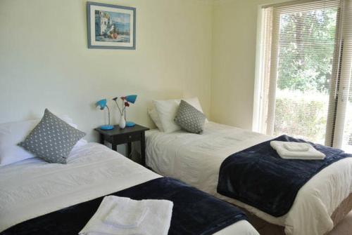 a bedroom with two beds and a window at Apple Blossom Retreat in Bright