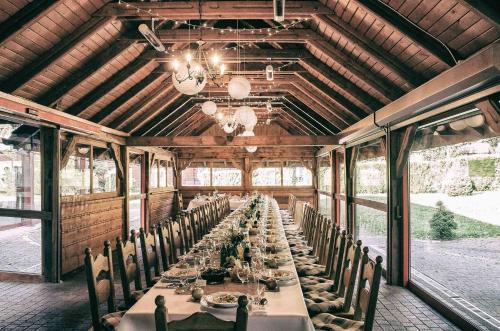a long dining room with a long table with chairs at Dolina Leśnicy SKI & SPA Resort in Brenna