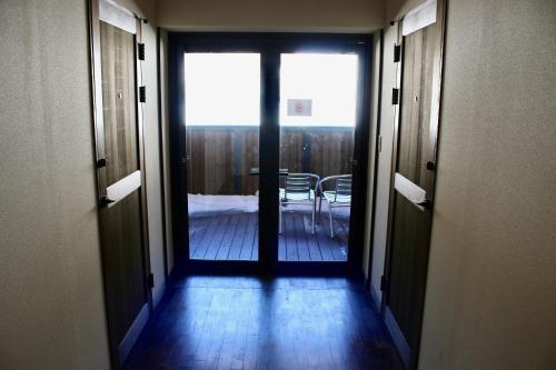 a hallway with a door leading to a dining room at Spa Lodge Redwood Inn in Takayama