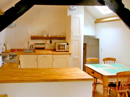 ベトウス・ア・コーエドにあるBwthyn-y-Pairのキッチン(木製テーブル、テーブル、椅子付)