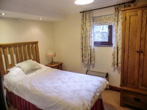 a bedroom with a large bed and a window at Ghyll Bank Bungalow in Staveley