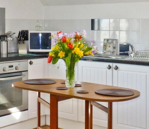 um vaso de flores sentado numa mesa numa cozinha em Sunnyvale em Bugle