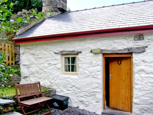 ベトウス・ア・コーエドにあるBwthyn-y-Pairの白石造りの家(木製のドアとベンチ付)