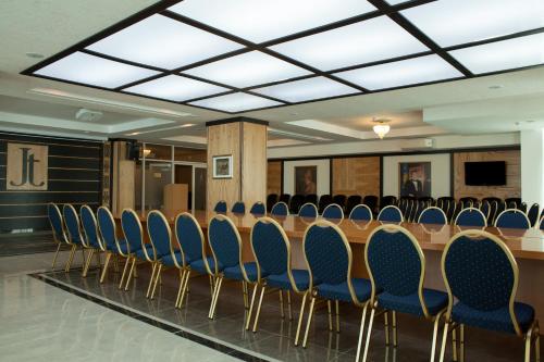 a conference room with a long table and chairs at Jumbaktas Astana Hotel in Astana