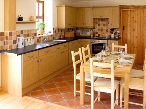 a kitchen with a wooden table and chairs and a table and chairsktop at Nuffies Cottage in Elton