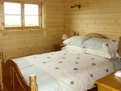 LivertonにあるThornlea Log Cabinのログキャビン内のベッドルーム1室