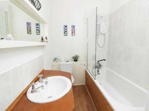 a bathroom with a sink and a tub and a shower at Top Flat in Tighnabruaich