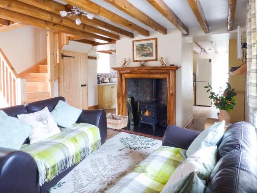 a living room with a couch and a fireplace at Fell View Cottage in Bootle