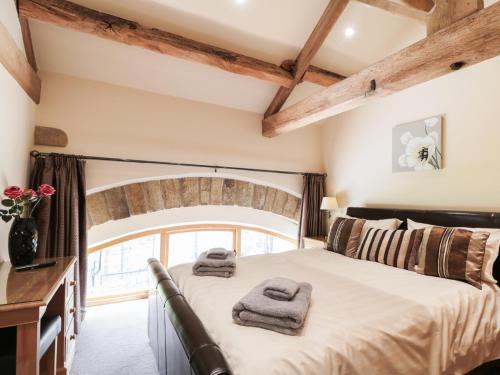 a bedroom with a bed with towels on it at Stoneycroft Barn in Langsett