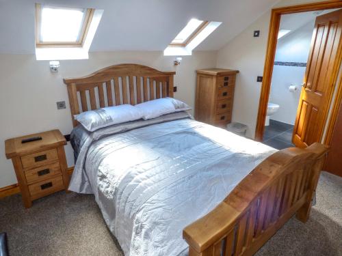 a bedroom with a large bed with a wooden head board at Corner Croft in Earl Sterndale