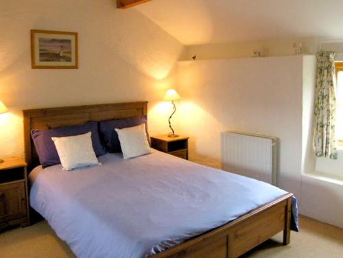 a bedroom with a large bed with two pillows at Pen y Parc in Meliden