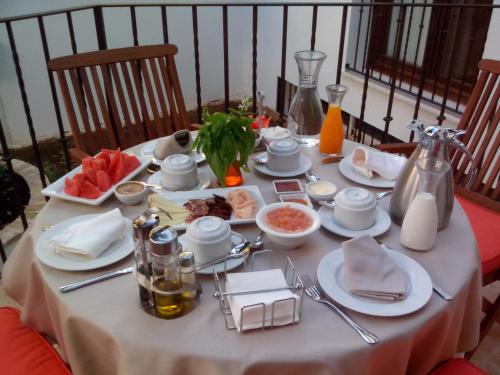 a table with a white table cloth with food on it at La Posada de Quijada in Granada