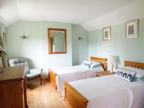a hotel room with two beds and a mirror at Shortmead Cottage in Biggleswade