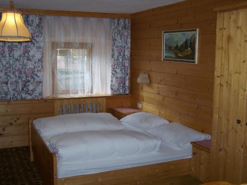 een slaapkamer met 2 bedden en een raam bij Pension Holzknechthof am See in Neustift im Stubaital