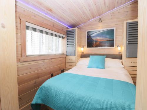 ステイスにあるOld Joiners Shopの木製の部屋にベッド1台が備わるベッドルーム1室があります。