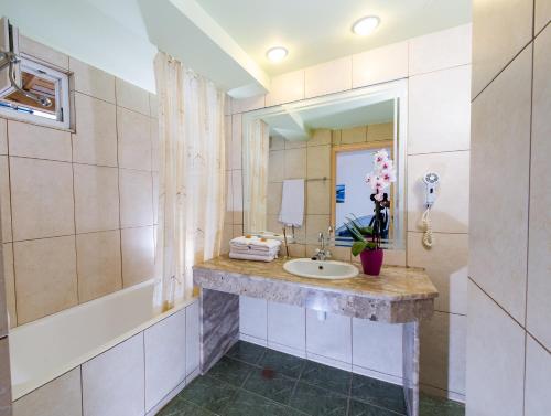 a woman taking a picture of herself in a bathroom mirror at Creta Hotel in Agios Nikolaos