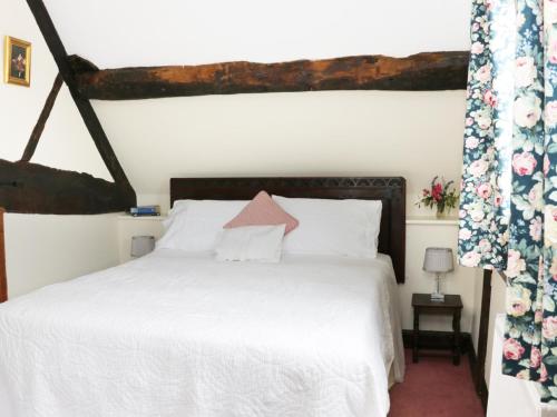 a bedroom with a bed with a white bedspread at 7 Gretton in Cardington