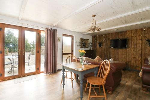 uma sala de estar com uma mesa e um sofá em Foxley Wood Cottage em Horsham Saint Faith