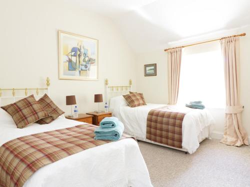 a bedroom with two beds and a window at Bannatyne Lodge in Newtyle