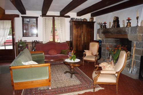a living room with a couch and a fireplace at Le Moulin du Bignon in Lassy
