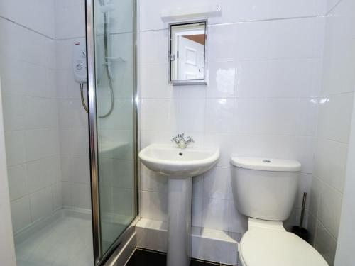 a bathroom with a toilet and a sink and a shower at Apartment 3 Marian Y Mor in Pwllheli