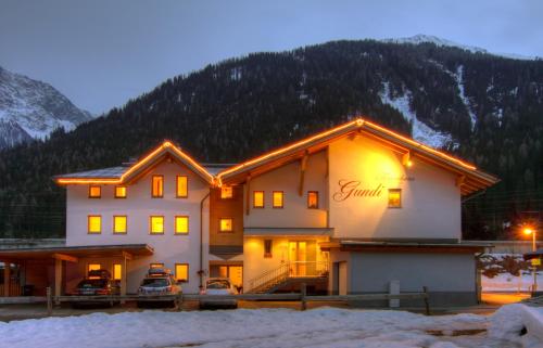 a building with lights on it in the snow at Ferienhaus Gundi in Pettneu am Arlberg