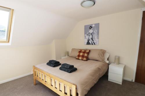 a bedroom with a bed with two towels on it at Station Apartment in Llanberis