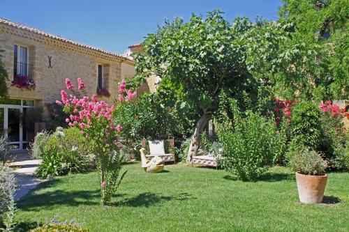 a garden with a bench and trees and flowers at Chambres d'Hôtes La Maison de Léonie in Collias