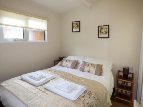 a bedroom with a bed with two towels on it at River's Nook in Llangynog