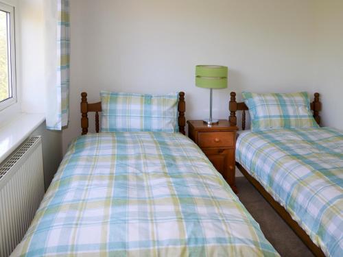 two beds sitting next to each other in a bedroom at Anglesey White Haven in Llandegfan