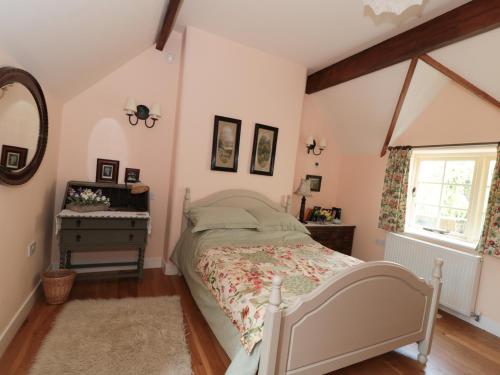 a bedroom with a bed and a dresser and a window at Just A Cottage, Newlands Farm in Swanwick