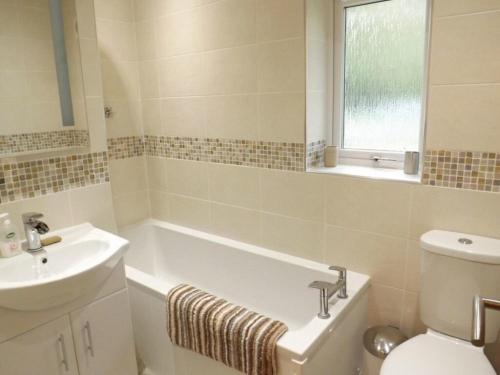 un bagno con vasca, lavandino e WC di Eribel Cottage a Threlkeld
