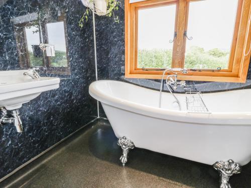 a bathroom with a bath tub and a sink at The Clydes in Tremeirchion